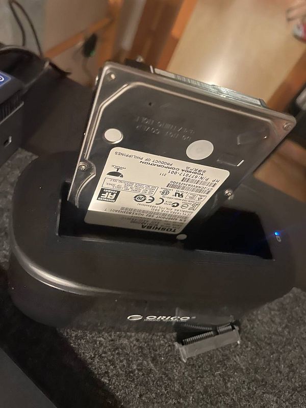 A hard drive is connected to a docking station for data recovery.