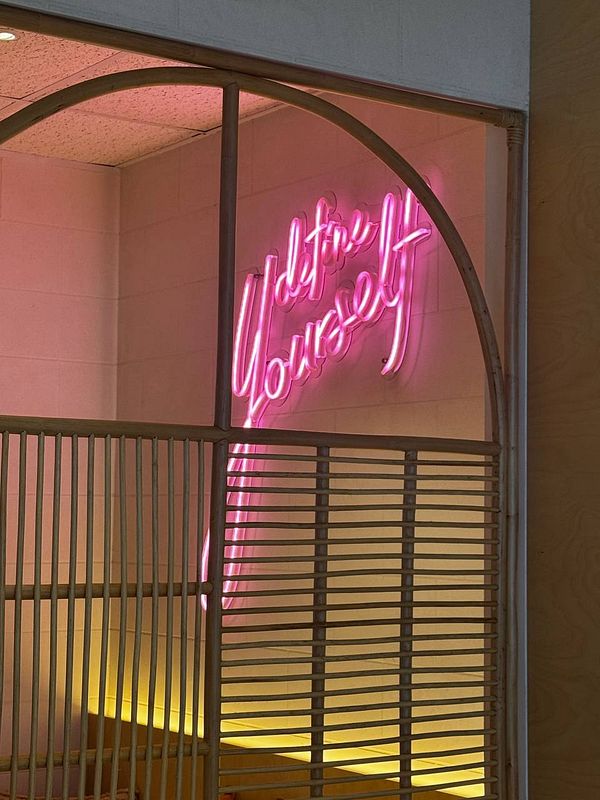 A neon sign with the phrase 'Define Yourself' is illuminated in a stylish interior space.