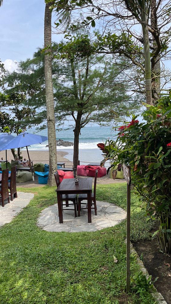 A serene beachside dining area with tables and colorful seating.