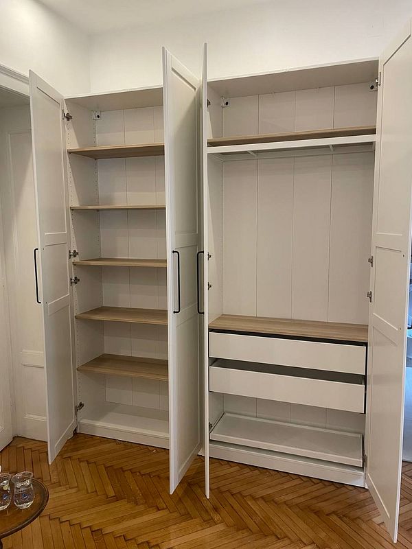 A newly built closet with multiple shelves and drawers.