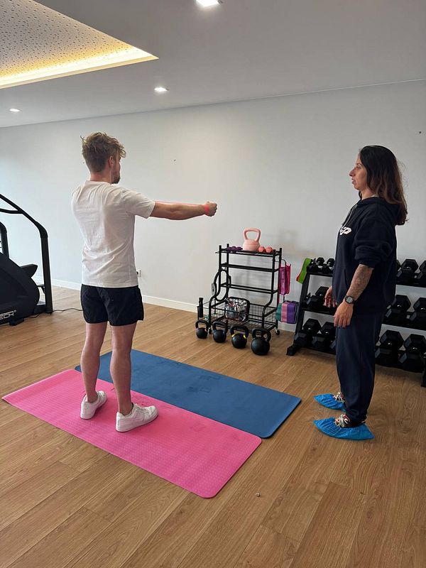 A personal training session is taking place in a home gym setting.