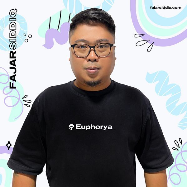 A person wearing a black t-shirt with the word 'Euphorya' printed on it stands against a colorful background.