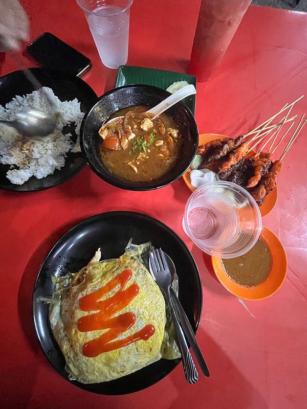 A vibrant dinner spread featuring various dishes on a red table.