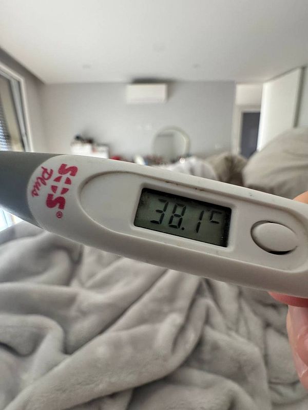 A digital thermometer displaying a temperature reading of 38.1°C.