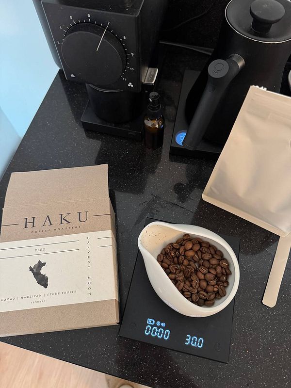 A coffee preparation setup featuring freshly roasted beans and a digital scale.