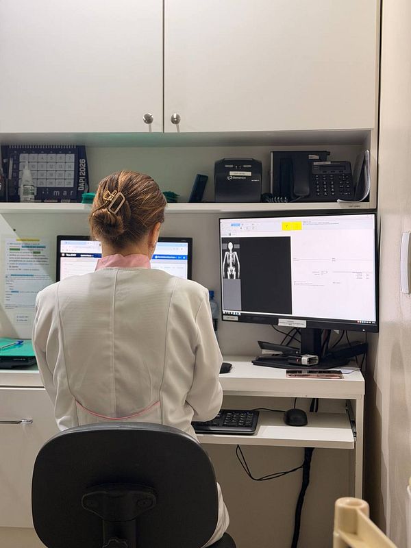 Medical imaging showing a colored DEXA scan of a human body with measurement data.