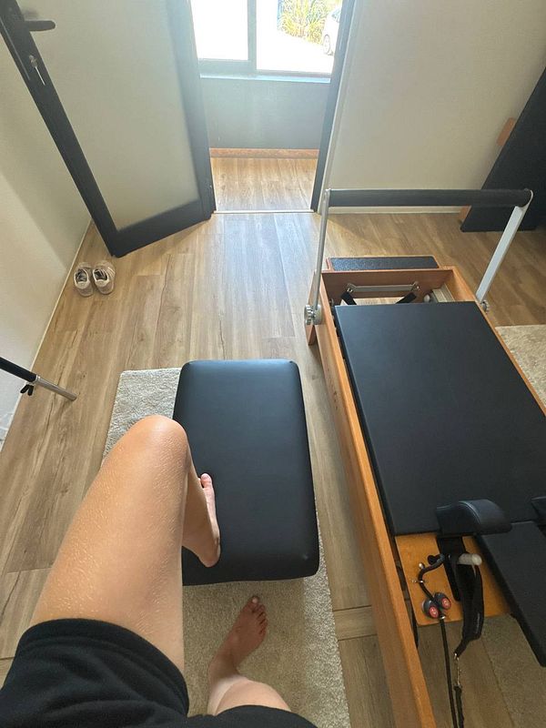 A person is preparing for a Pilates session in a well-lit room.