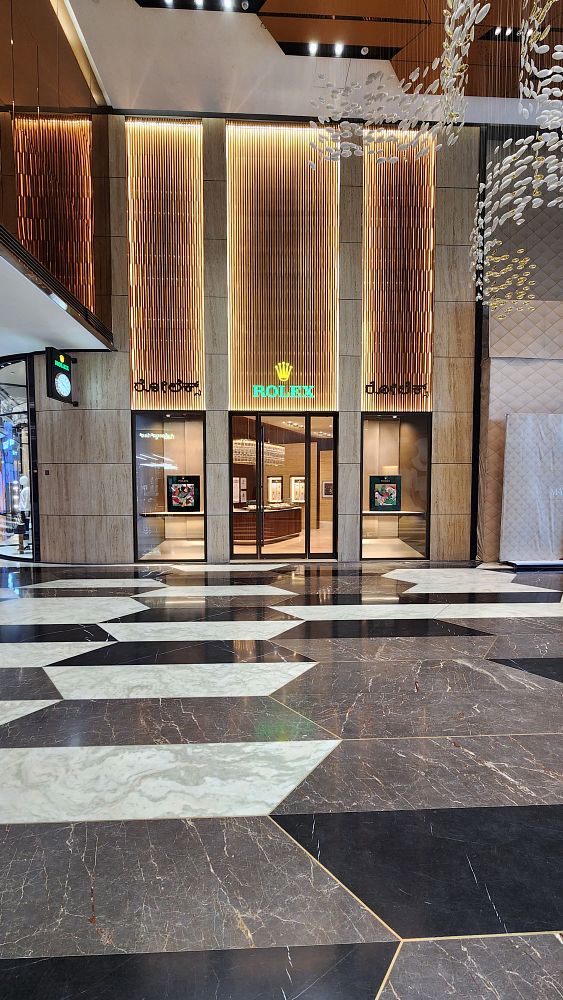 The image captures the entrance of a new Rolex boutique with elegant architectural features.