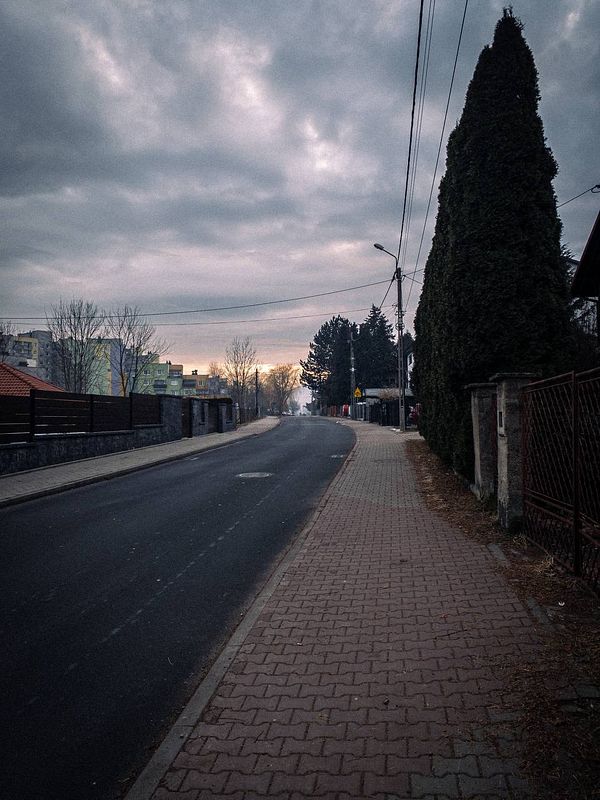 A quiet street scene during a morning walk with a cloudy sky.