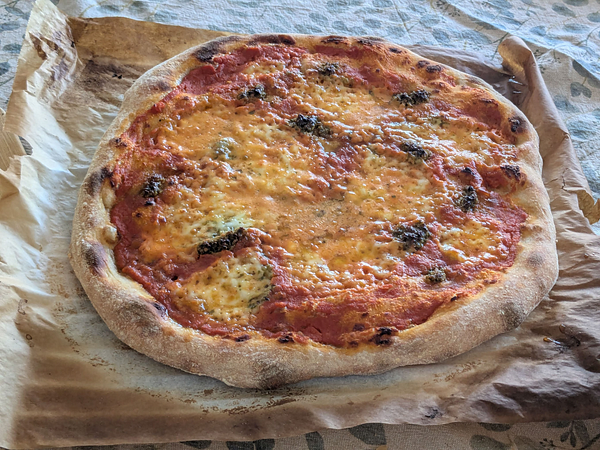 A freshly baked sourdough margherita pizza on parchment paper.