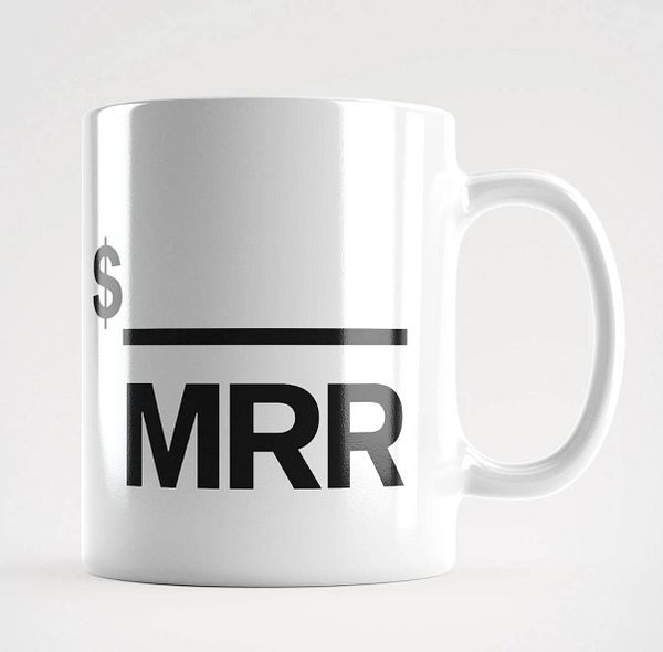A white mug featuring a bold design with the text '$ MRR' and a horizontal line.