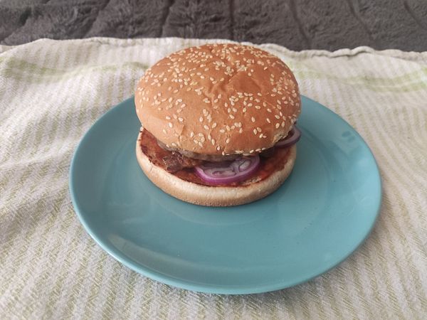 A homemade burger is presented on a blue plate.