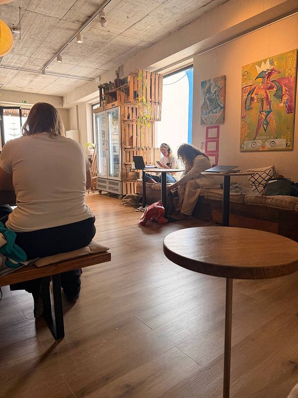 A lively hippie-style coffee shop interior featuring colorful decor and eclectic seating.