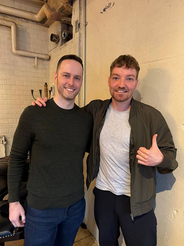 Two men pose together in a coffee shop in Tokyo.