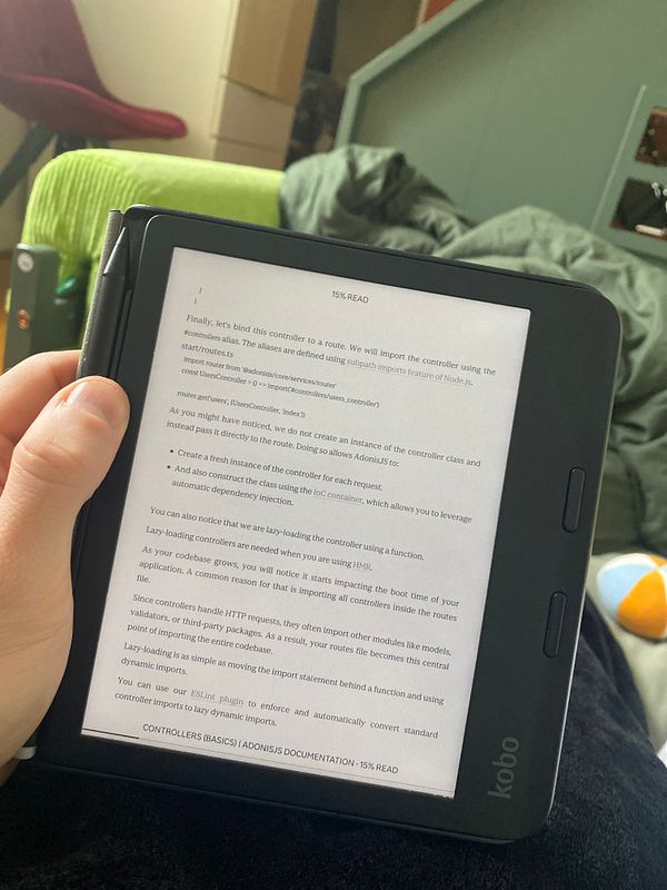 A person is reading AdonisJS documentation on an e-reader device.