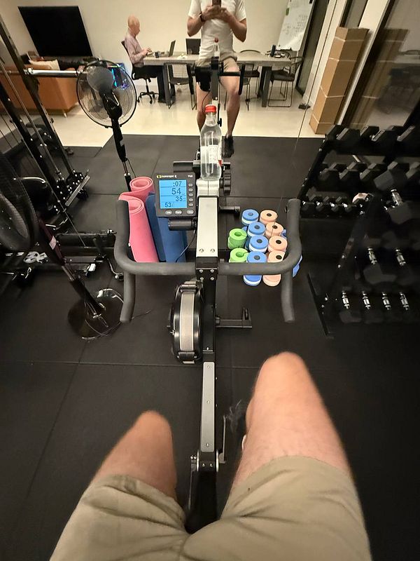 A person is using a rowing machine in a gym setting.