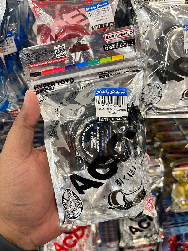 A hand holds a packaged Hyper Yoyo in a store aisle filled with similar products.