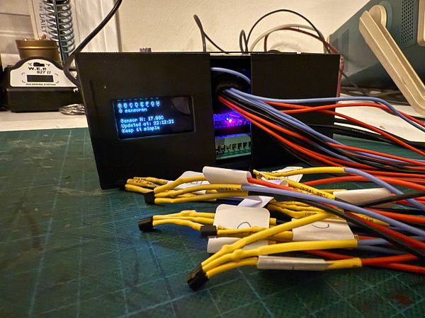 A 3D printed enclosure with an LCD display and multiple wires connected to it.