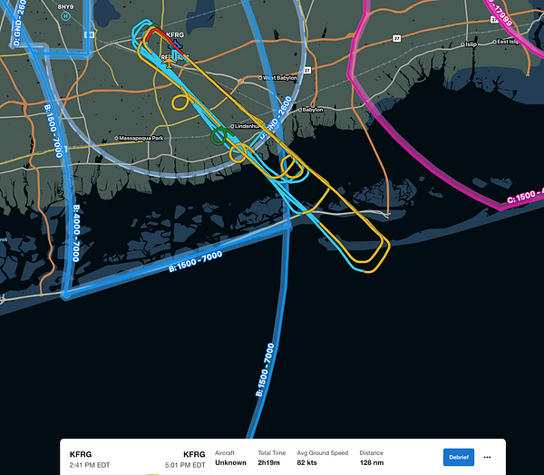 Aerial view of an airport runway and surrounding landscape with multiple aircraft landing and flight patterns visible.