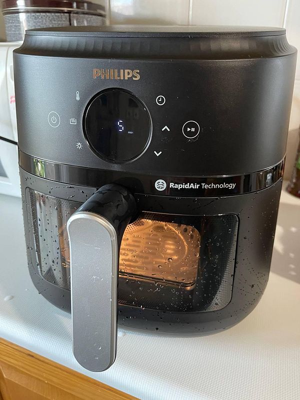 A new Philips air fryer is displayed on a kitchen countertop.