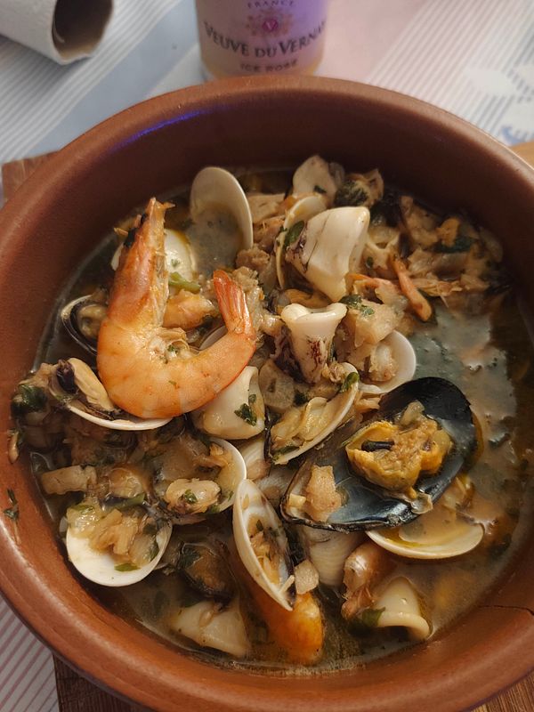 Top view of a cooked seafood dish featuring crab legs served on a blue plate.
