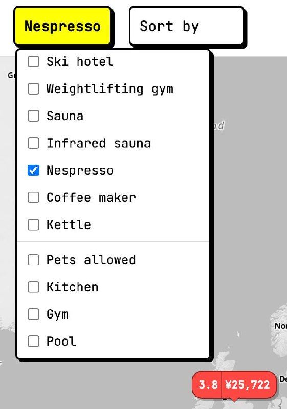 View of a hotel room showing modern amenities including a bed, seating area, and kitchenette.