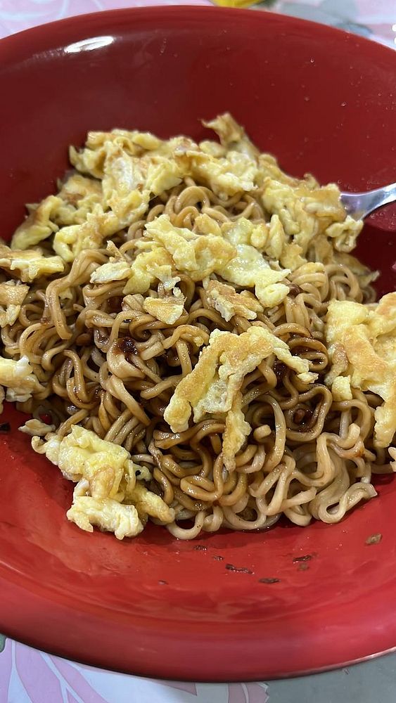 A bowl of noodles topped with scrambled eggs.