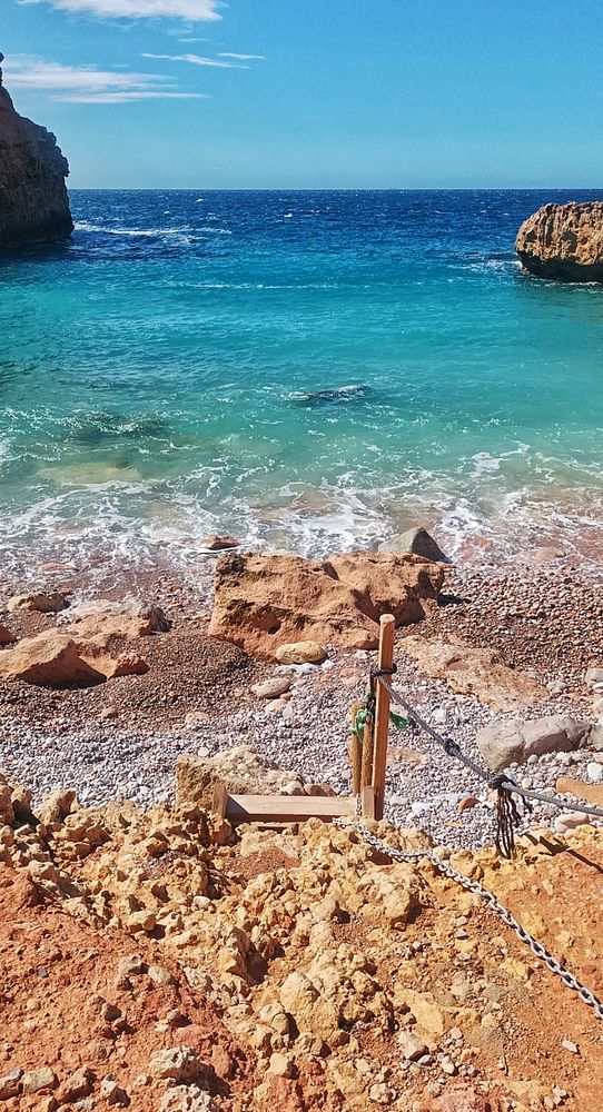 A woman enjoying a grassy field under clear skies, featuring a scenic outdoor setting with blue skies and scattered clouds.