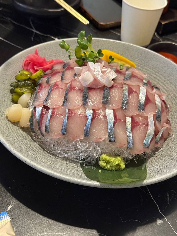 Close-up of Korean sushi rolls arranged on a wooden board with chopsticks and a dipping sauce bowl.