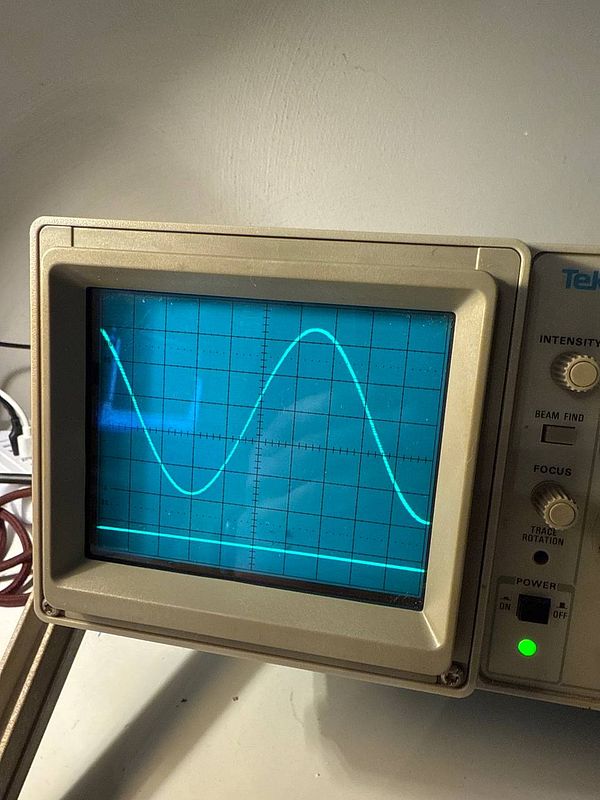 An oscilloscope displaying a sine wave signal.