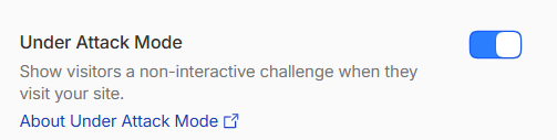 Screenshot of a Slack chat conversation discussing enabling under attack mode with a sarcastic emoji.
