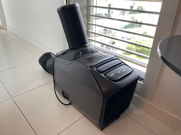 A boxed EcoFlow Delta 2 portable power station displayed on tiled floor next to a sofa.