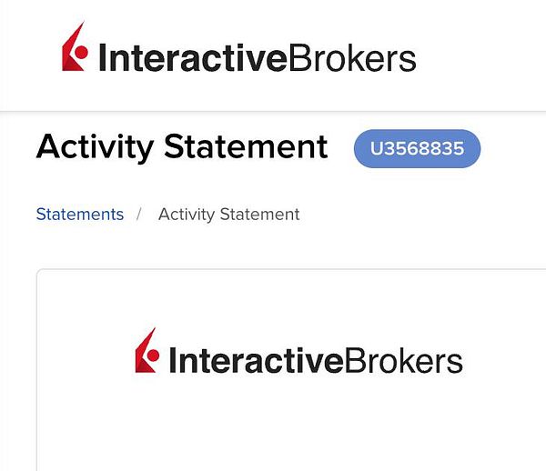 A laptop on a desk with open invoices or financial documents, a notebook, and other office items suggesting work on accounting or bookkeeping tasks.