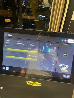 A fitness machine display shows workout statistics and a city view at night.