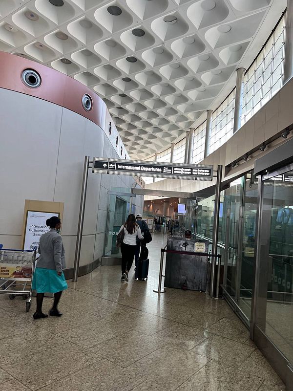 A busy airport terminal leading to the International Departures area.