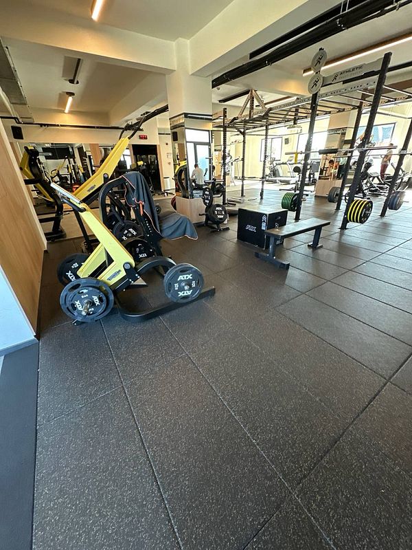 A well-equipped gym space featuring various workout machines and weights.
