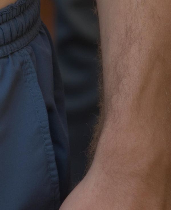 A close-up of a person's arm and torso, showcasing skin texture and clothing details.