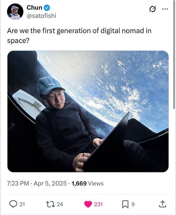 A person is working on a laptop while gazing out of a spacecraft window at Earth.