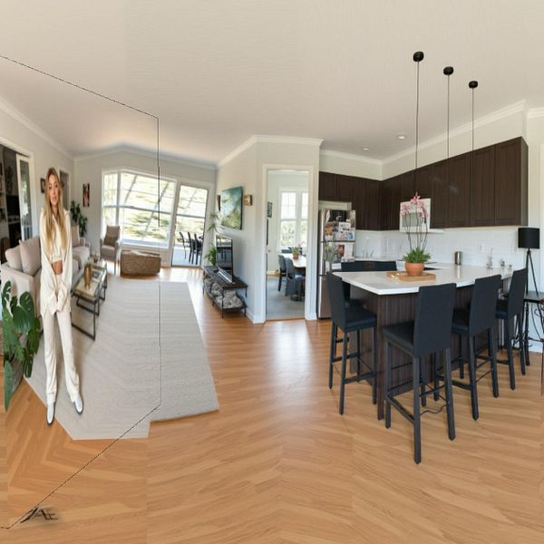 A modern, well-lit interior space featuring a kitchen and living area with a person standing in the foreground.