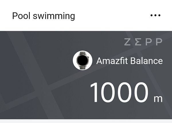 A large outdoor swimming pool area under a clear blue sky with colorful inflatable play structures.