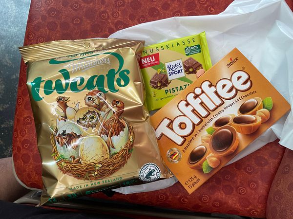 A bustling city street filled with cars, taxis, and people enjoying a day out.