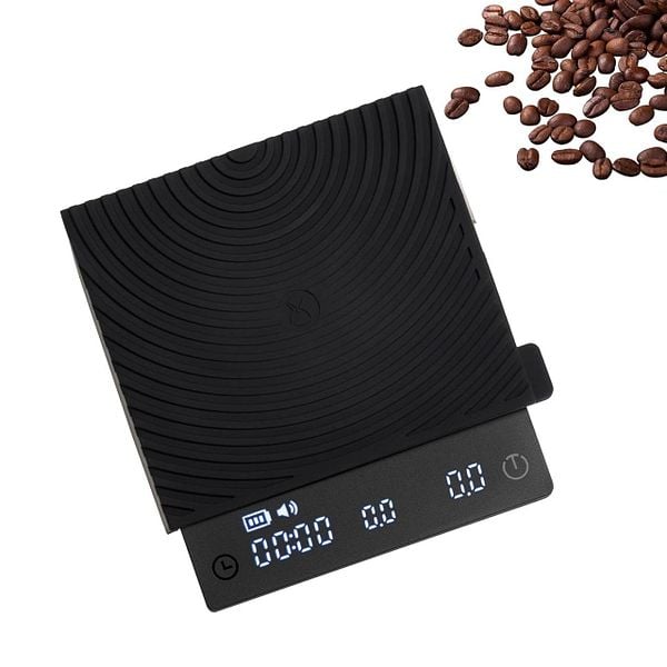 A digital coffee scale is displayed alongside scattered coffee beans.