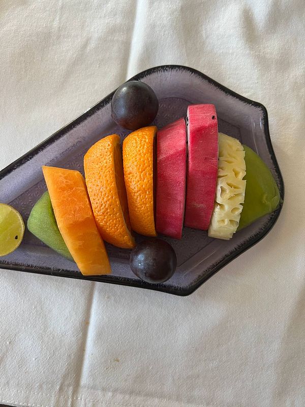 A colorful assortment of sliced fruits arranged on a decorative plate.