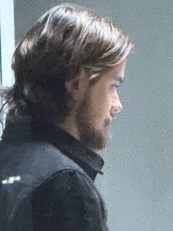 A profile view of a man with long hair and a beard.