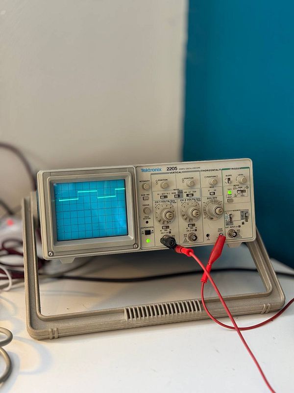 An old Tektronix oscilloscope is displayed on a work surface.