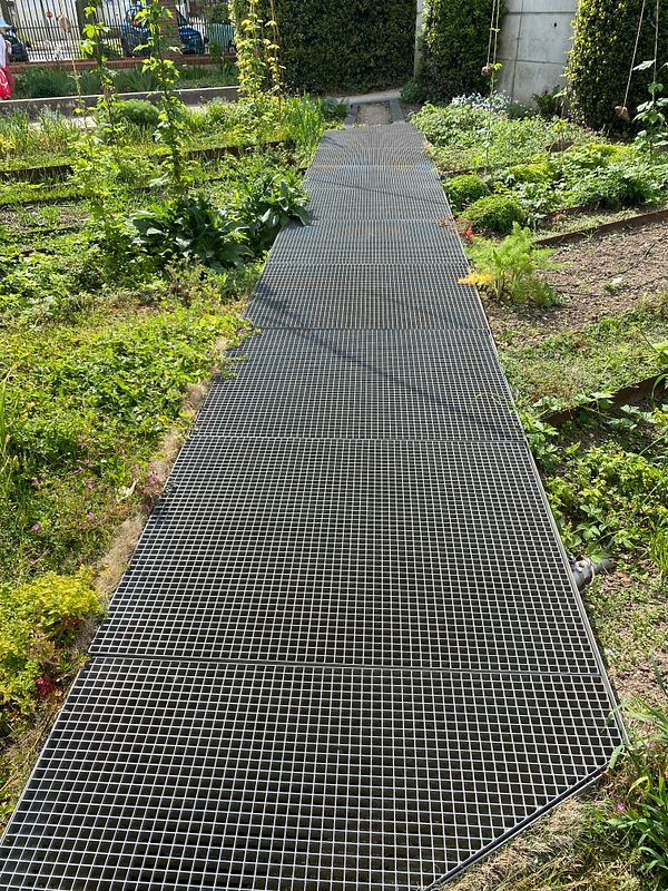 Photograph of a garden with diverse plants and solar-powered lights, showcasing sustainable gardening techniques.
