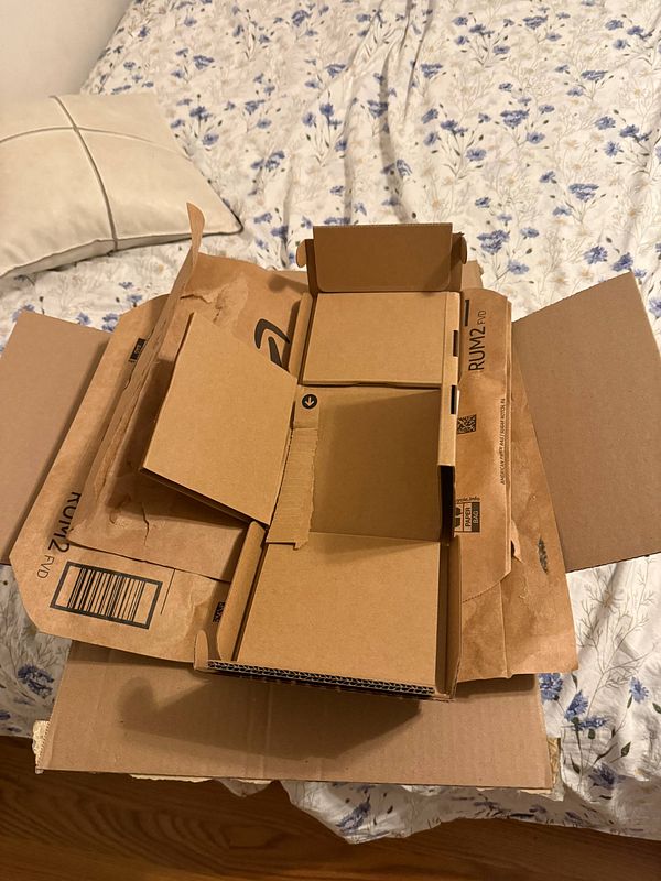 An assortment of cardboard boxes is arranged on a bed, ready for packing gifts.