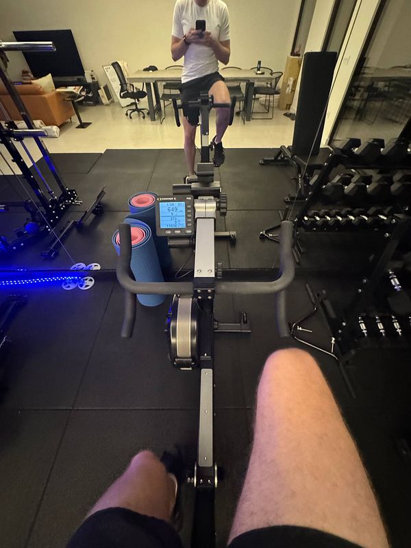 A person is using a rowing machine in a home gym setting.