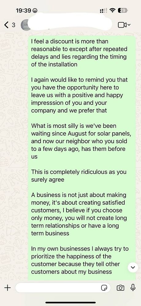 A WhatsApp message expressing frustration over delays in solar panel installation.