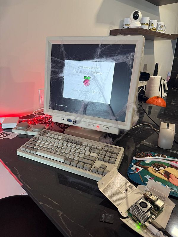 A Raspberry Pi setup is displayed on an old monitor with a keyboard and various accessories on a desk.